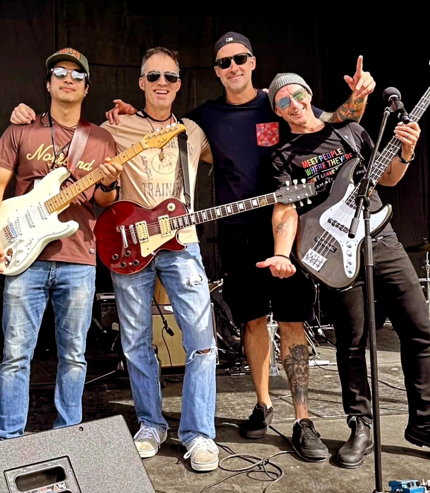 Arsh Rai performing on stage with his bandmates from The Bluestone Collective, each holding a guitar or bass.